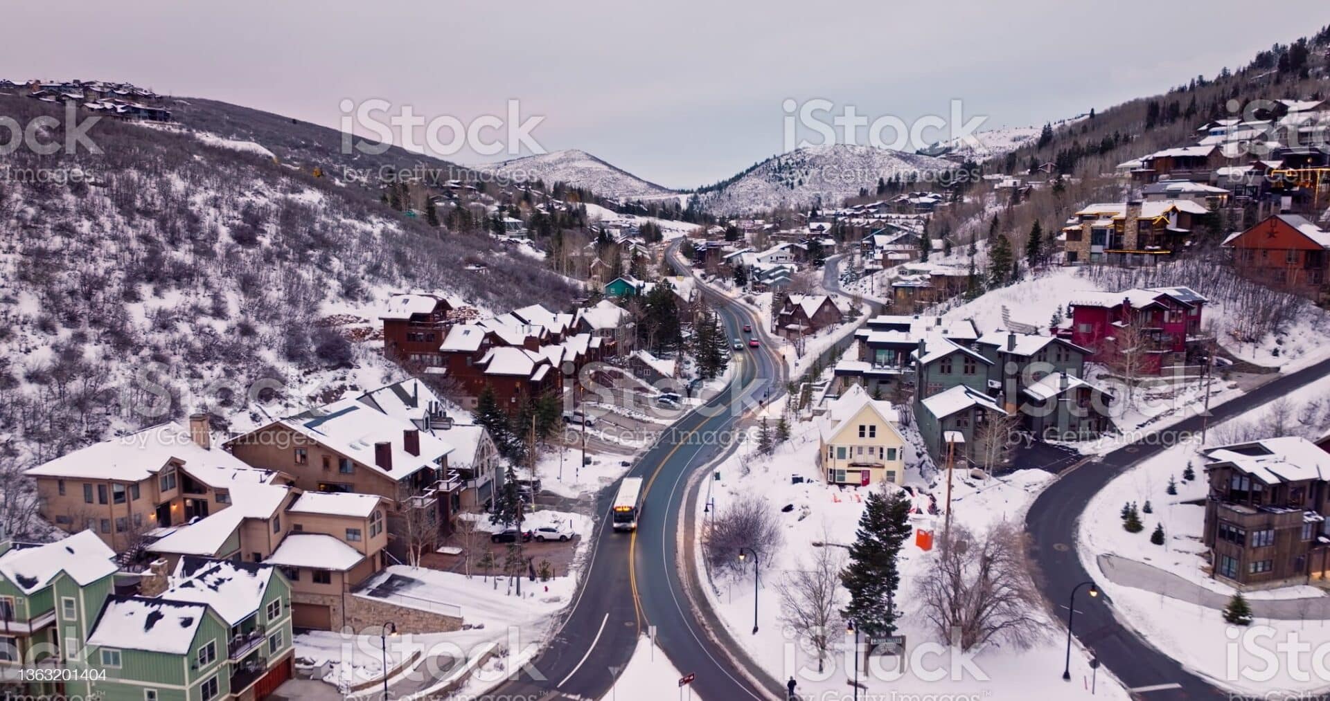 Aerial shot of Park City, a ski resort town in Summit County, Utah on a winter afternoon, looking down on the snow covered rooftops with the mountains rising around the town.